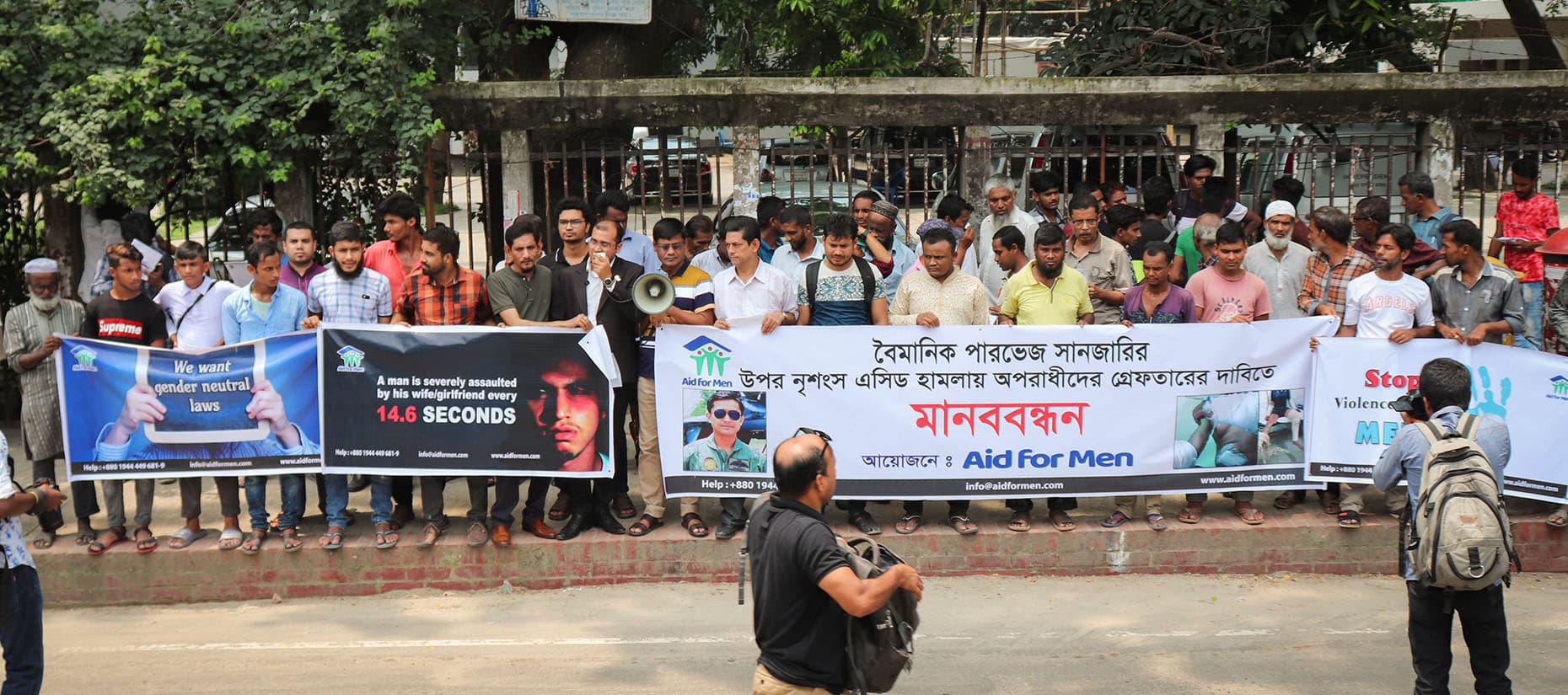 রাস্তার পাশে ব্যানার হাতে মানববন্ধনে দাঁড়ানো অংশগ্রহণকারীরা